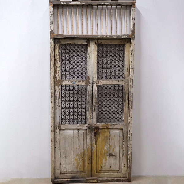 Old wooden gate with iron grids